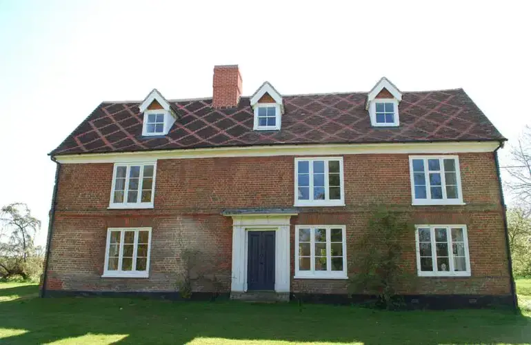 Brick house with a tiled pitched roof and chimney in Kingston