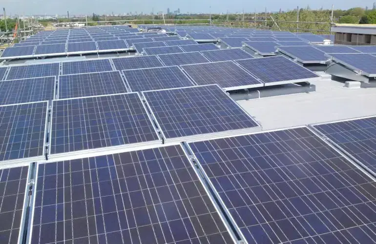 Rows of solar PV panels across a large flat roof in Norwood