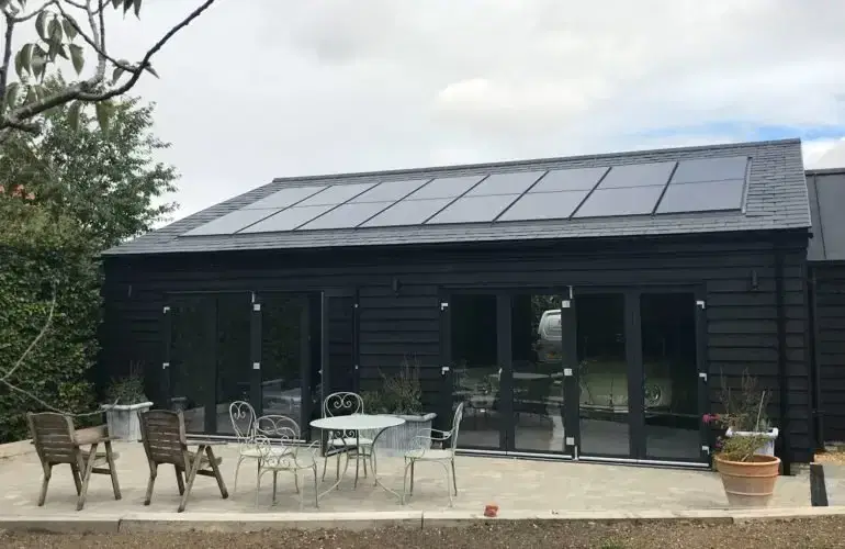 Solar panels on the roof of a timber-clad garden building in Girton
